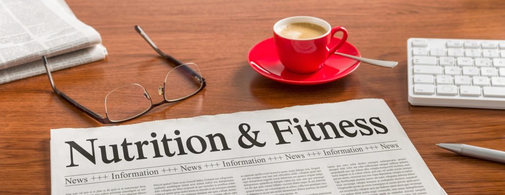 A newspaper on a table that says, "Nutrition & Fitness." Expressing the importance of both dieting and exercising when you have a 100 pound weight loss journey ahead of you.