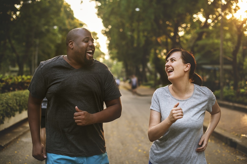 A happy man and woman jogging together- learn how the combination of healthy diet and exercise helps you lose weight even faster
