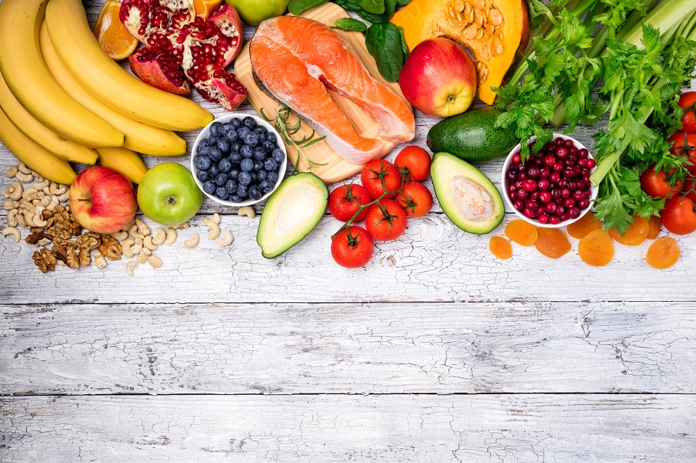 Colorful healthy foods on a wooden background, representing the types of foods that are in the free 8 week weight loss plan